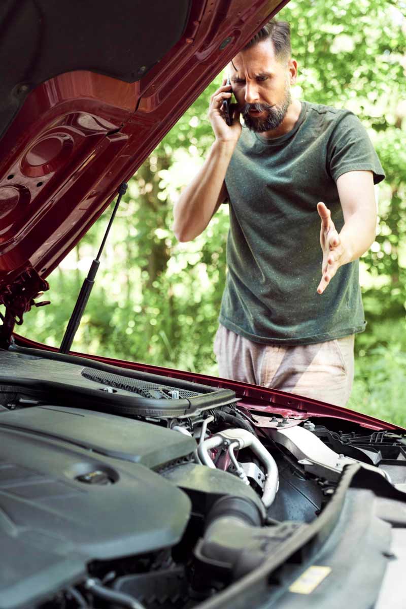 Junger Mann prüft Getriebeschaden bei Schrottauto Ankauf Heiligenhaus